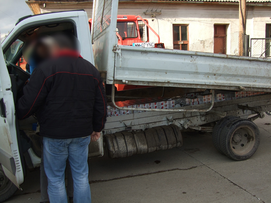 Depozit de ţigări de contrabandă, sub camioneta cu lemne