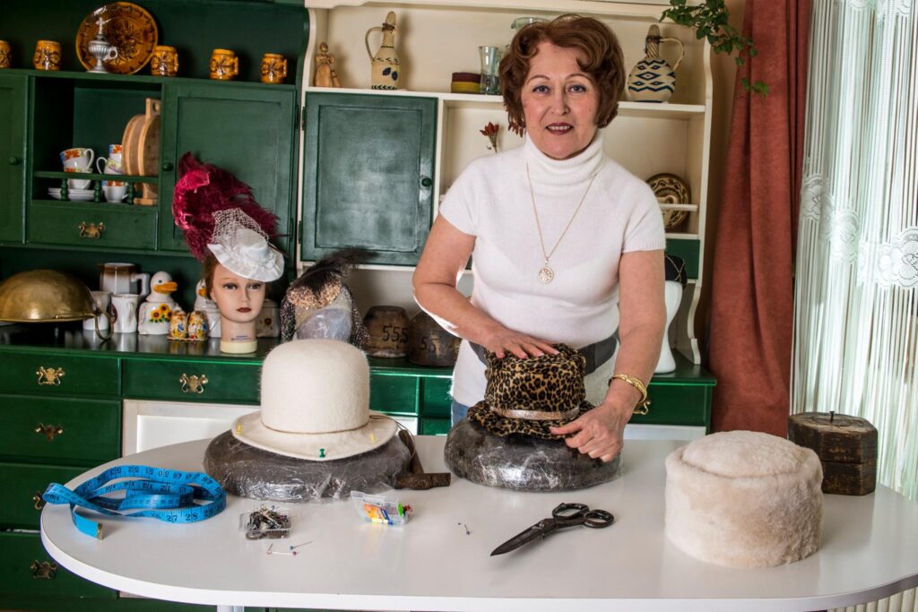 O femeie din Oradea face pălării după calapoadele Reginei Elisabeta