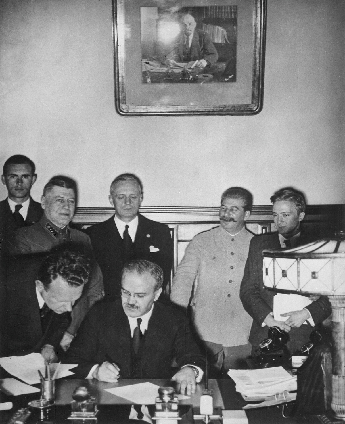 Molotov semnând Pactul Secret cu Germania. În spate, Ribbentrop și I.V. Stalin